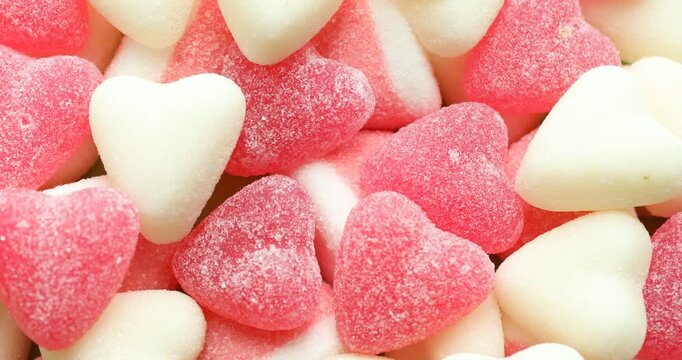 Delicious heart shaped candies as background, rotating