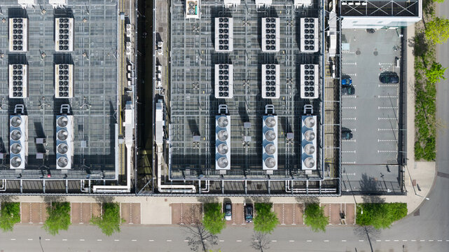 Aerial view of the Equinix Data Center roof featuring industrial cooling units and HVAC systems next to a parking lot and green trees in Amsterdam, Noord-Holland, Netherlands.