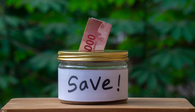 Saving Money Concept with Indonesian Rupiah in Glass Jar Labeled SAVE