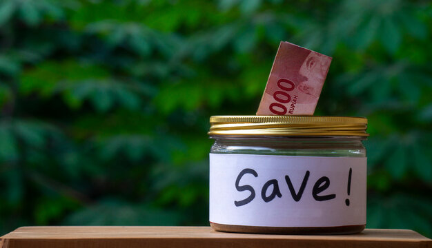 Saving Money Concept with Indonesian Rupiah in Glass Jar Labeled SAVE