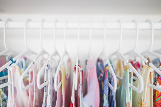 toddler girl dresses on hangers in organized wardrobe shallow depth of field