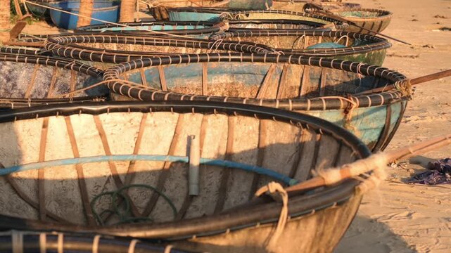 Stacked Boats At Vietnam Shoreline. Detailed View Of Tied Boats Arranged On Beach Sand During Dusk. Coastal Scene Showing Warm Light Coracles Stacked And Tied On Da Nang Shoreline