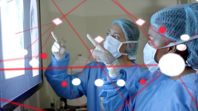 Two MDs pointing at medical scan screen, initiating red-node overlay climbing while reviewing scans