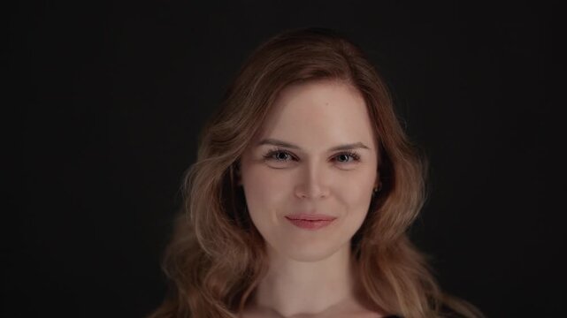 Authentic joy and happiness a close-up shot of a woman smiling and laughing against a black background.