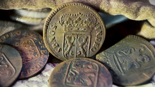 Close up video of an antique VOC 1 duit Gelderland coin showing the obverse side with a crowned shield and the inscription &ldquo;INDEO SP. NOS.&rdquo;