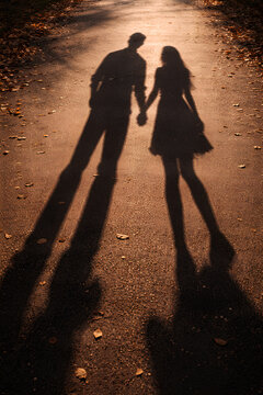Romantic Long Shadows of a Couple Holding Hands at Sunset