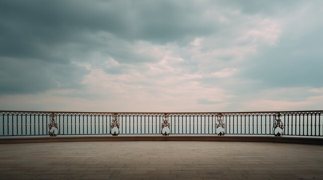 Empty terrace with ornate railing under cloudy sky