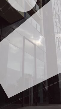 Vertical video: Graphic overlays sliding in camera panning up past glass facade showing tower scale