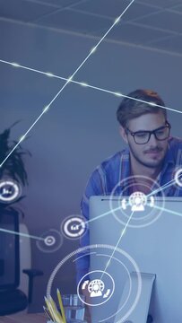 Vertical video: Dev leaning at screen, IT, focusing and forming HUD icons into data web for insight