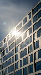 Obraz premium Modern office building with sun reflection on windows corporate architecture under blue sky