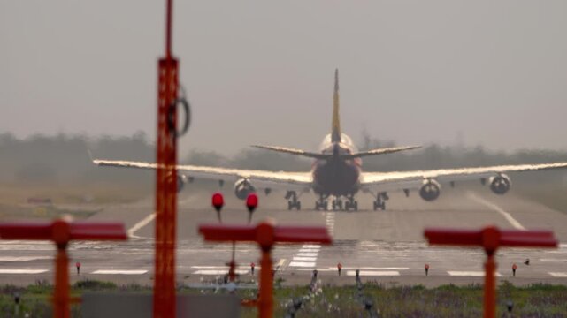 A huge wide-body four-engine airliner on the runway, rear view. Concept aviation, flight, tourism, cargo transportation, travel