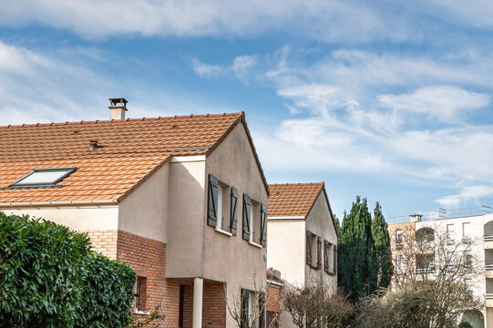 Residential houses in suburban France, detached homes beside a multistory residential building. The scene illustrates French banlieue housing, suburb architecture and local real estate.