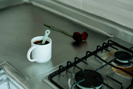 Minimal kitchen scene with coffee cup on stove, simple lifestyle, calm morning routine and home environment.