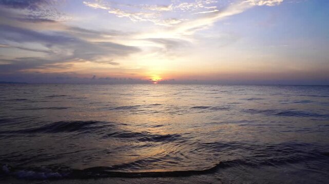 Dramatic Purple and Blue Sunset Sky Over Open Ocean with Golden Sun Reflection on Sea Surface