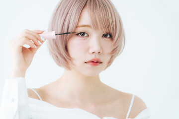 Fototapeta premium マスカラをつけるハイトーンショートボブヘアの女性