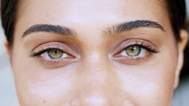 Close-up Detailed Texture of Female Green Eyes with Long Eyelashes and Natural Eyebrows Staring Intensely. High Resolution Beauty Macro Shot of Ethnic Woman for Mascara, Makeup and Brow Commercials 4k