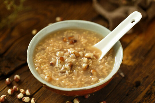 Warm multigrain porridge with rice and beans in bowl on rustic wooden table