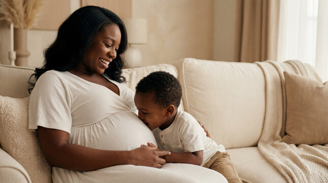 Mother's Day expectant mother with toddler son on couch showing sibling bond affection anticipation for lifestyle magazine editorial content photography