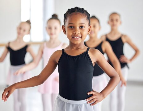 Young girls in tutus practice ballet, with focus on a happy, dark-skinned girl in front