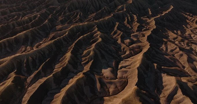 Close aerial establishing medium of eroded desert ridges forming abstract badlands patterns in Utah