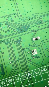 General view of an electronic printed circuit board with tracks and connections. Vertical video