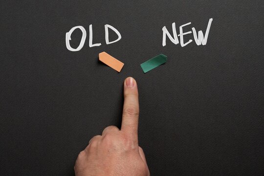 Hand pointing between old and new options illustrating transformation, innovation and decision making between outdated and modern solutions.