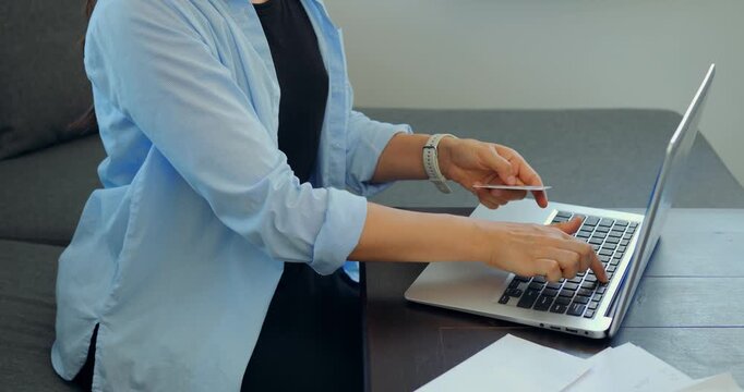 Customer using card at computer checkout. Person completing online purchase with secure focus. Shopper securely completing internet transaction using credit card at computer station
