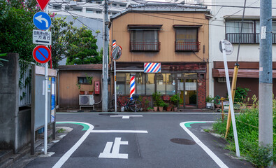 Naklejka premium 昭和レトロな雰囲気の日本の理髪店と下町の路地裏にある道路標識の風景