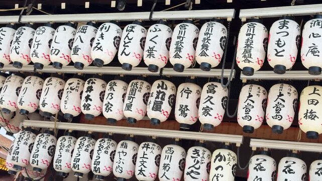 Rows of traditional Japanese lanterns with calligraphy hang in rows, offering a cultural glimpse.