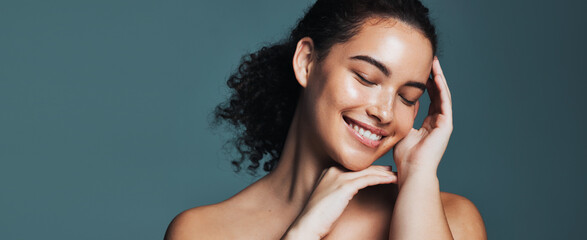 Skincare, beauty and happy woman with touch, wellness glow aesthetic and smooth texture for space. Facial shine, dermatology and person with banner for natural skin, self care and studio background © peopleimages.com
