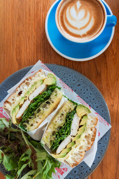 Chicken & Avo Focaccia with a flat white at a cafe in Australia