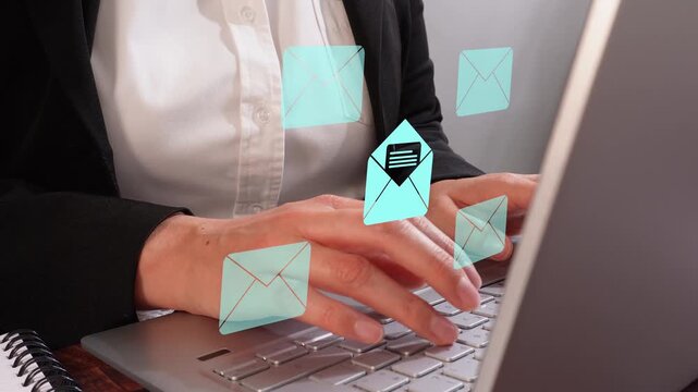 Close-up of a businesswoman's hands working on her computer with an animation of several closed and one open envelope icons.