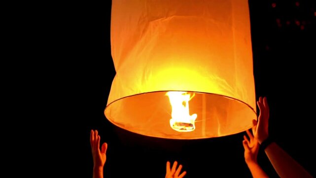 Young people release floating lanterns delicate in the night sky at Yi Peng Traditional celebration in Thailand, realistic photography, 4k 60Fps