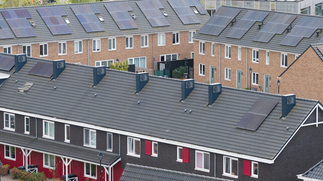 Aerial view of modern terraced houses in the Nobelhorst district featuring solar panels and heat pump units on rooftops Almere, Flevoland, Netherlands.