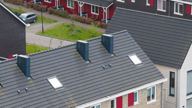 Aerial view of rooftops with installed heat pumps on residential buildings, highlighting clean energy, home electrification, sustainable heating, and the energy transition.
