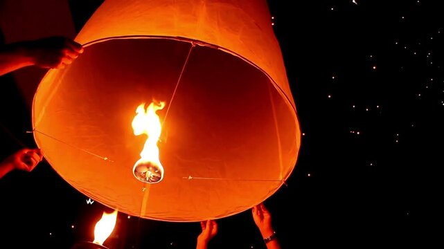 Young people release floating lanterns delicate in the night sky at Yi Peng Traditional celebration in Thailand, realistic photography, 4k 60Fps