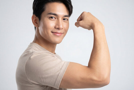 Strong asian man smiling and flexing biceps to show fitness and health