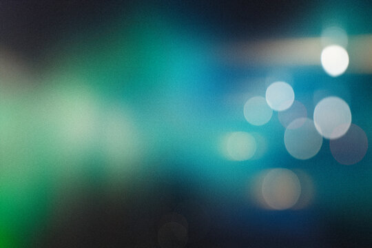 Abstract background creating a bokeh effect with blurred light circles reflecting a modern atmospheric glow. Blue green gradient light circles bokeh effect