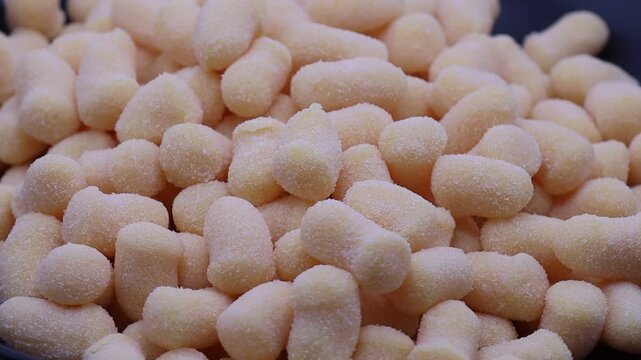 Rotating view of raw potato gnocchi pasta dumplings covered in flour.