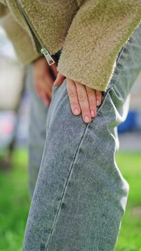 Footage highlights knee discomfort, a hand gently rubbing the leg, suggesting pain relief or muscle strain. Moment expresses vulnerability, concern for well-being, seeking comfort from aching joint.