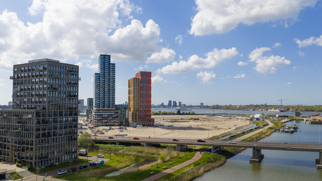 Aerial view of the modern Sluisbuurt residential towers and construction site along the IJ river under a cloudy sky in Amsterdam, North Holland, Netherlands.