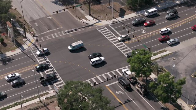 erial drone view of busy suburban four way intersection with heavy traffic flow showcasing transportation infrastructure commuting patterns and urban development in growing Florida community