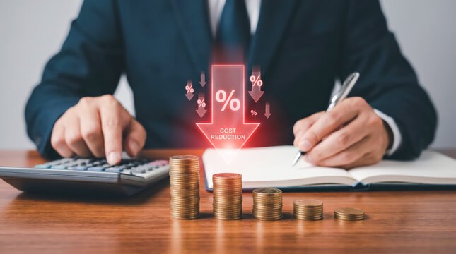 Businessman calculating cost reduction strategies with stacks of coins and digital downward arrow graphic
