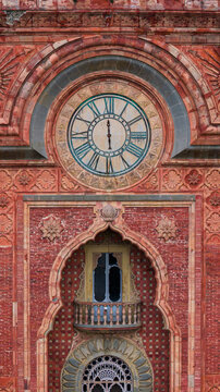 Aerial view of the intricate Moorish facade of Sammezzano Castle featuring a large clock and ornate brickwork in Reggello, Tuscany, Italy.