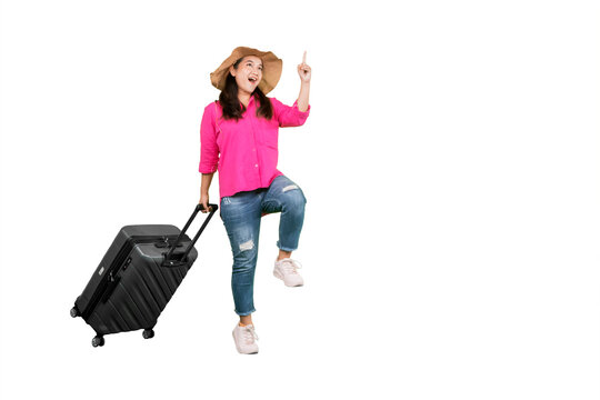 Excited Asian Woman Traveler Jumping with Suitcase and Pointing Upward on White Background