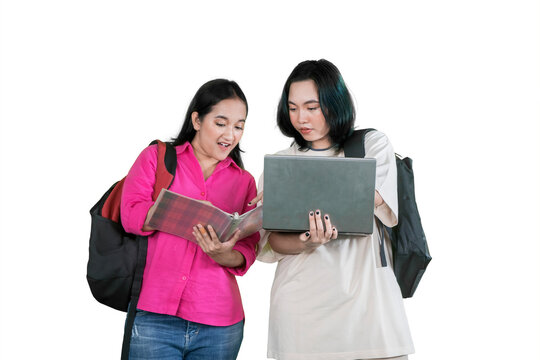 Two Happy Female University Students Collaborating with Laptop and Notebook