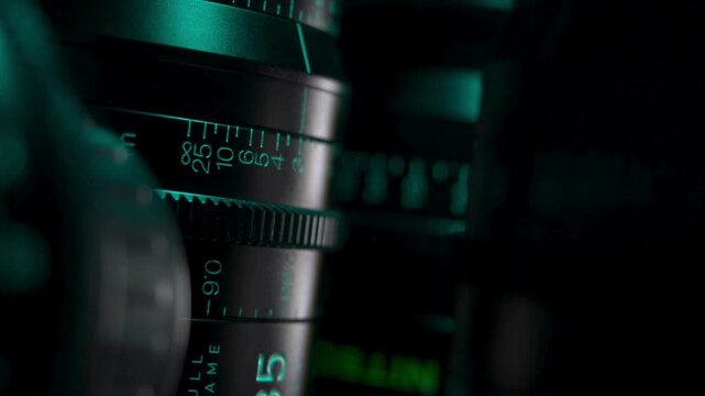 Detailed shot on the lens scale of film camera while the zoom wheel is turning. Television, movie, film video camera lens while Zooming in, close up.