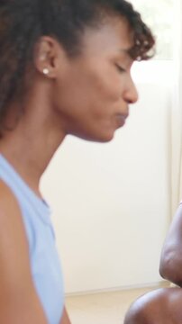 Vertical video: After pause leaning woman blue top closing eyes, pursing lips at home with forearm