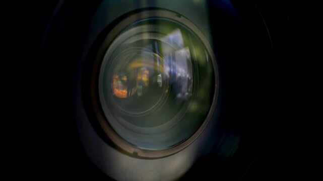 macro shot of a professional video camera while it's lens is zooming. Camera Lens. Internal objective lens of a camera. light swipe through the lens.
