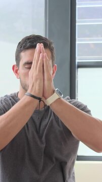 Vertical video: Lifting arm on inhale man joining palms lowering to chest calming at home watch